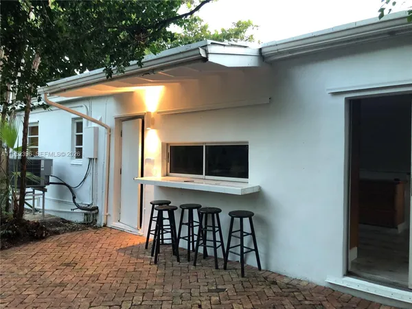 a backyard of a house with table and chairs