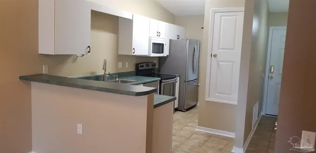 a kitchen with stainless steel appliances granite countertop a refrigerator and a stove