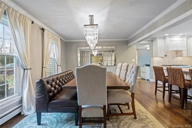 a dining room with furniture a chandelier and wooden floor
