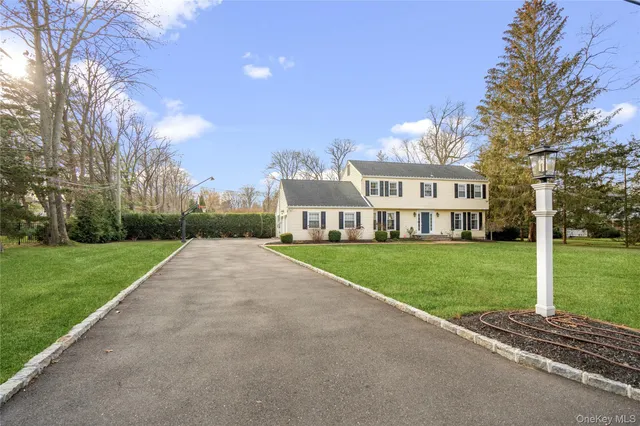 a view of a big house with a big yard and large trees