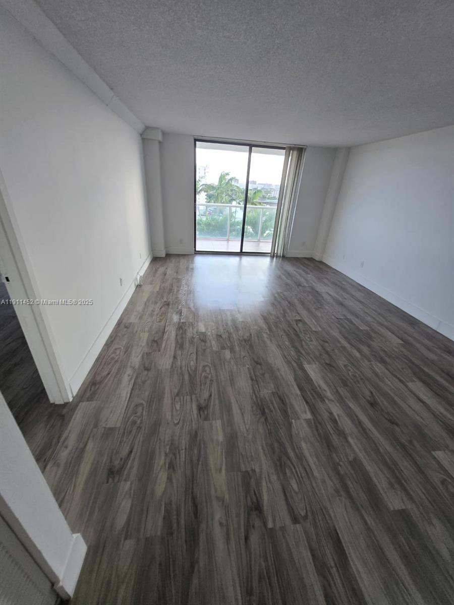13499 Biscayne Boulevard, Unit 604 North Miami, FL 33181 - Photo 1 of 14 wooden floor in an empty room with a window