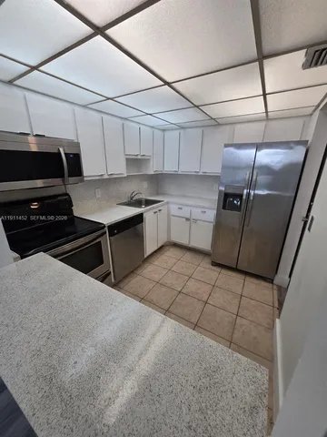 a kitchen with stainless steel appliances granite countertop a sink a stove and cabinets