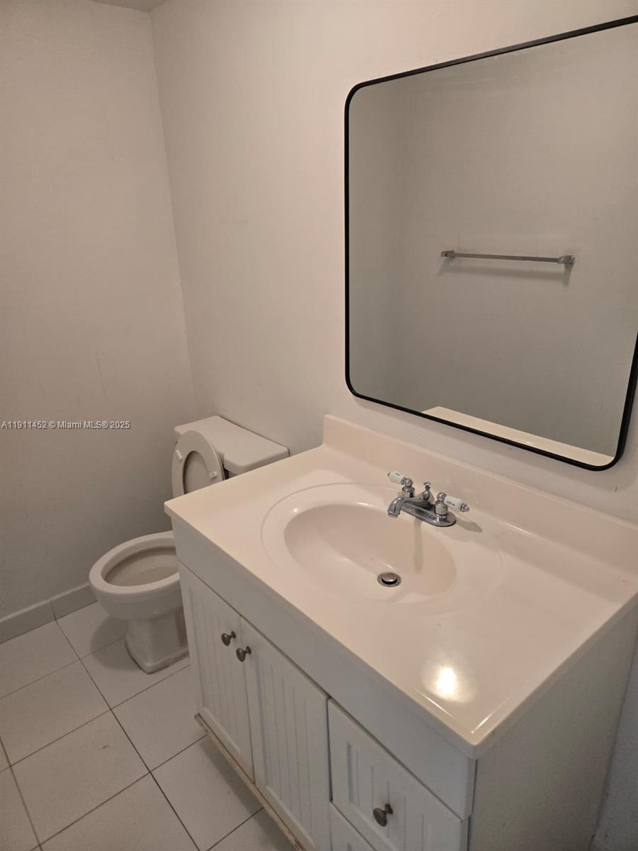 13499 Biscayne Boulevard, Unit 604 North Miami, FL 33181 - Photo 7 of 14 a bathroom with a sink a toilet and mirror