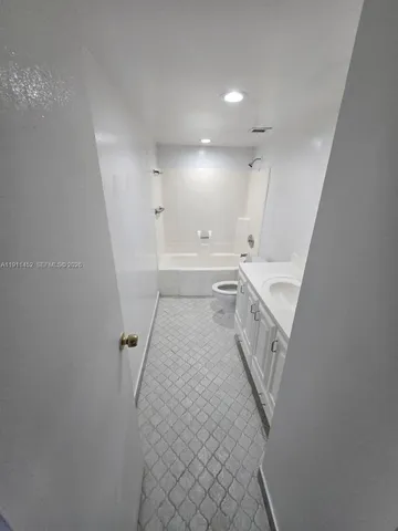a bathroom with a double vanity sink a mirror and a bathtub