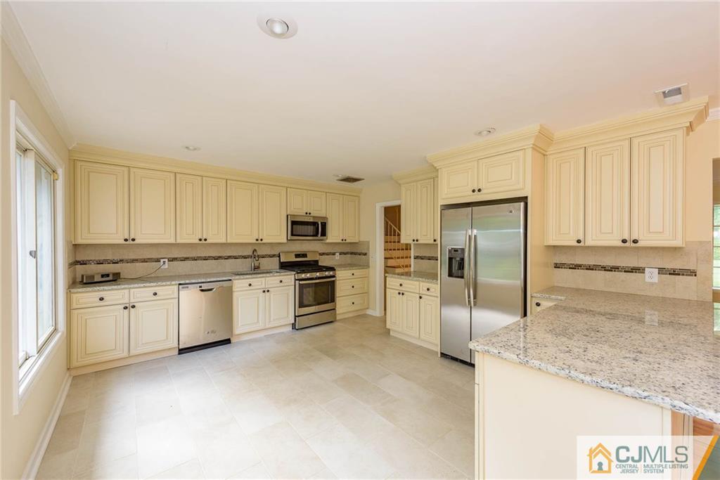 565 Foothill Road Bridgewater, NJ 08807 - Photo 5 of 25 a kitchen with granite countertop a refrigerator and a sink