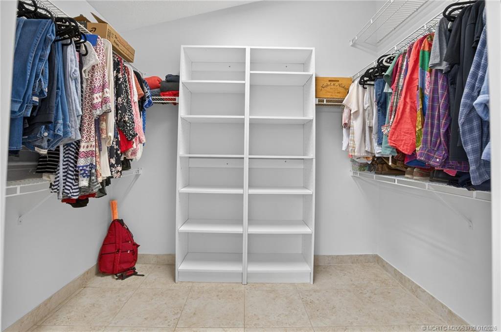 9275 Southeast Mercury Street Hobe Sound, FL 33455 - Photo 15 of 65 a view of walk in closet with clothes