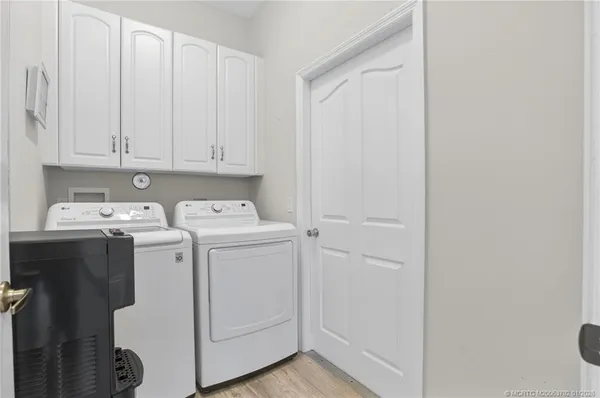a living room with furniture kitchen view and a chandelier