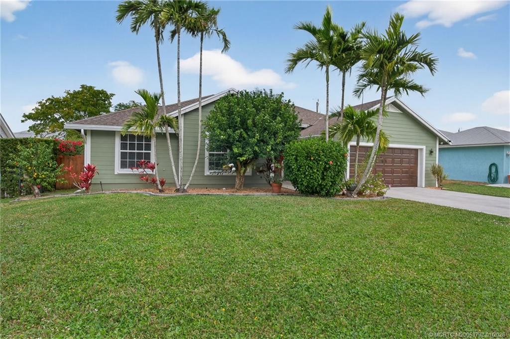 9275 Southeast Mercury Street Hobe Sound, FL 33455 - Photo 2 of 65 a palm tree sitting in front of a house with potted plants