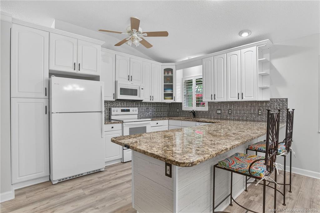 9275 Southeast Mercury Street Hobe Sound, FL 33455 - Photo 25 of 65 a kitchen with kitchen island a sink stove and refrigerator