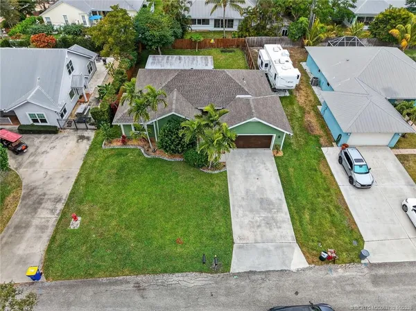 an aerial view of a house with swimming pool and large trees