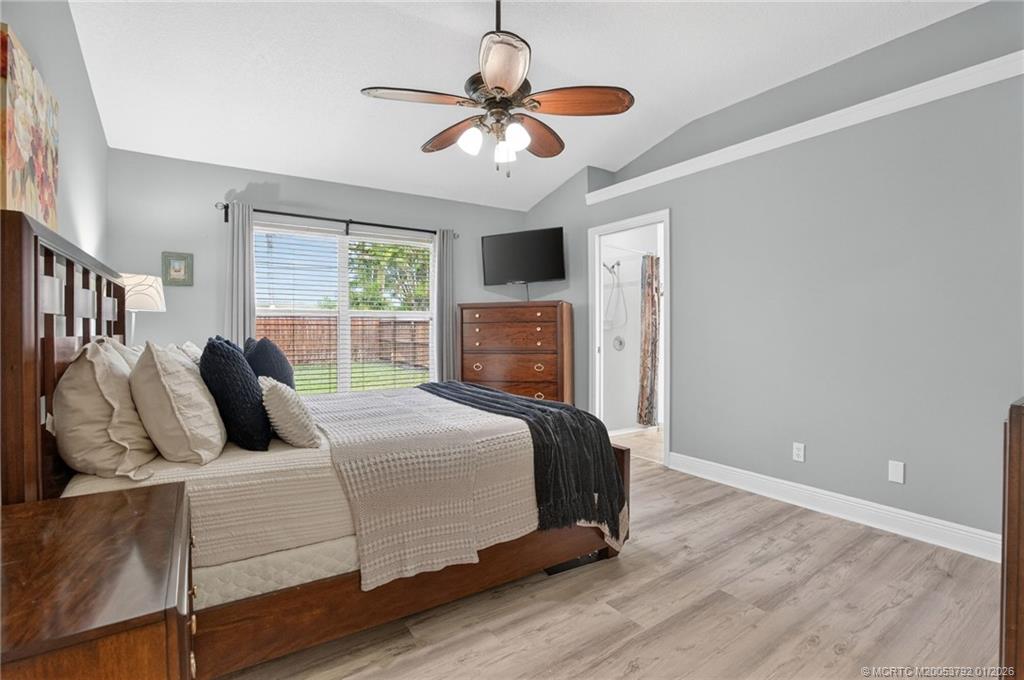 9275 Southeast Mercury Street Hobe Sound, FL 33455 - Photo 6 of 65 a bedroom with a bed and a ceiling fan