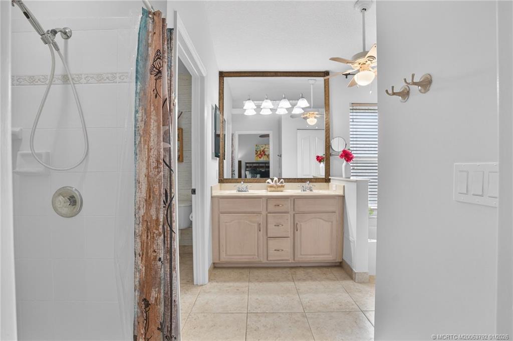 9275 Southeast Mercury Street Hobe Sound, FL 33455 - Photo 10 of 65 a bathroom with a shower sink and mirror