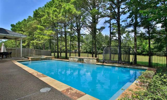 a view of a backyard with swimming pool