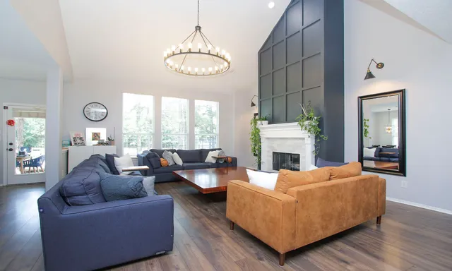 a living room with furniture a fireplace and a large window