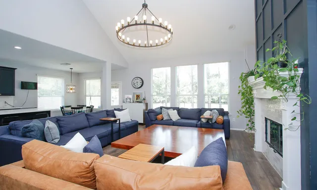 a living room with furniture chandelier and a fireplace
