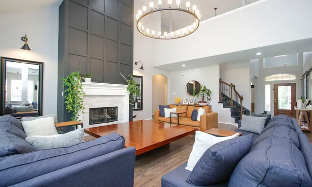 a living room with furniture a fireplace and a potted plant