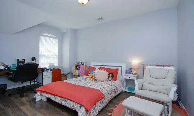 a bedroom with a bed and a chair