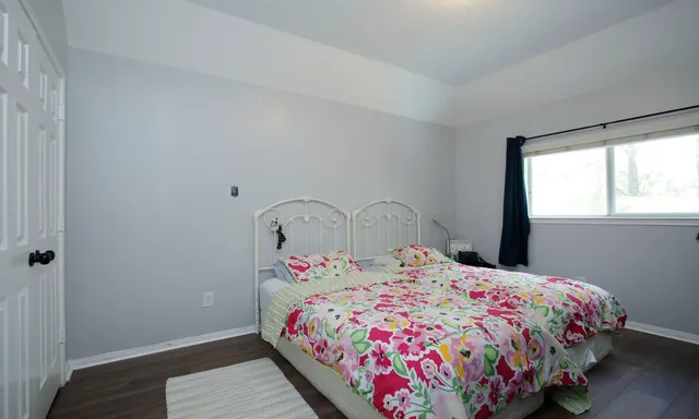 a bedroom with a bed dresser and a window