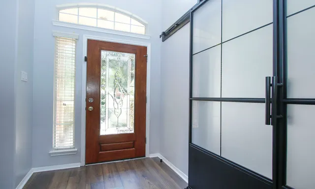 an empty room with wooden floor and windows