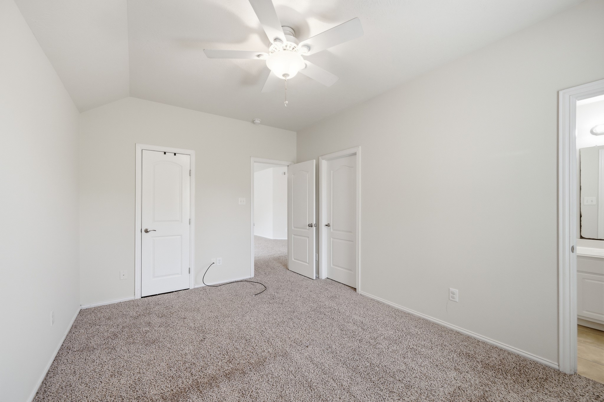 2117 Rushing Spring Drive Pearland, TX 77584 - Photo 30 of 42 Experience the tranquility of this spacious primary bedroom on the second floor, featuring plush carpeting, ample natural light, and a ceiling fan for ultimate comfort.