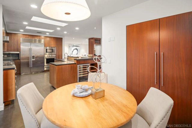 a kitchen with stainless steel appliances granite countertop a table and chairs