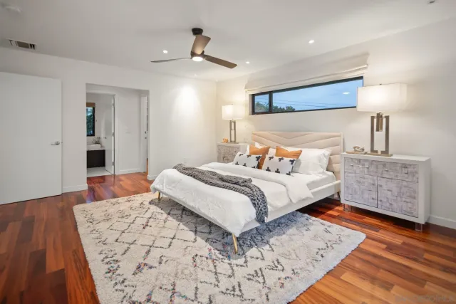 a bedroom with bed and wooden floor