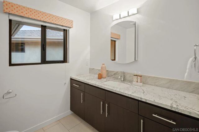 a bathroom with a granite countertop sink vanity and mirror