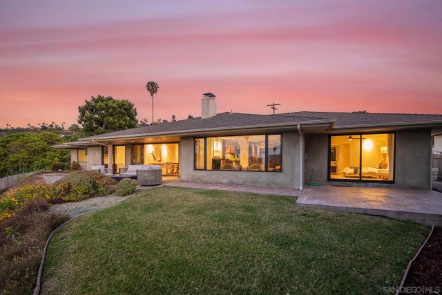 a view of a house with a backyard and a patio