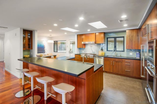 a kitchen with granite countertop sink stove and dining table