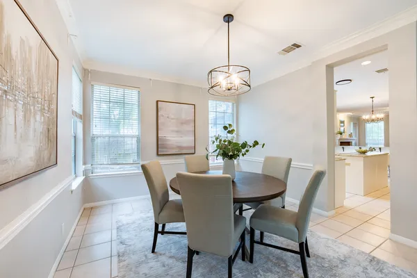 a dining room with furniture a chandelier and window