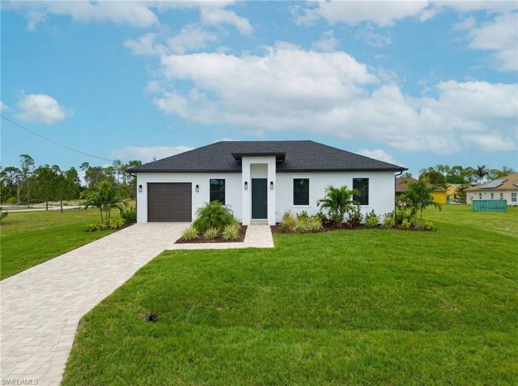 1213 Dodwin Street East Lehigh Acres, FL 33974 - Photo 1 of 28 a front view of a house with garden