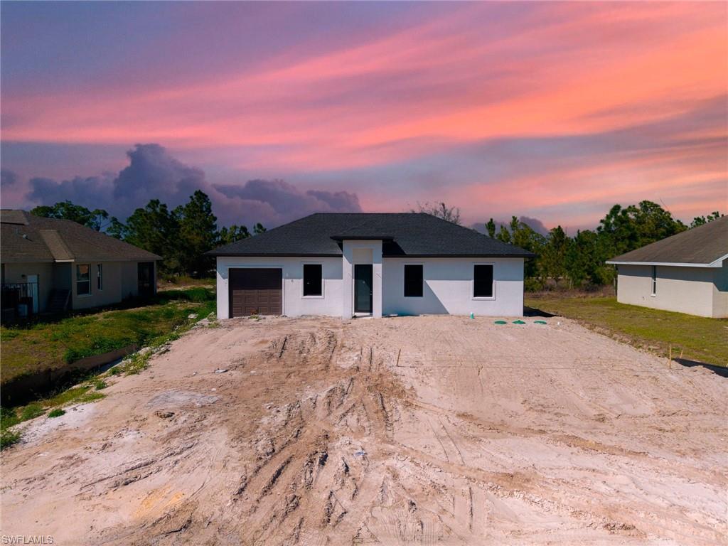 1213 Dodwin Street East Lehigh Acres, FL 33974 - Photo 23 of 28 a front view of a house with a yard and mountain