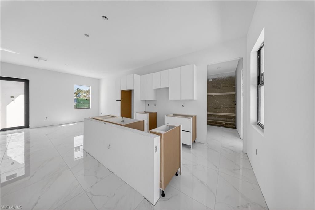 1213 Dodwin Street East Lehigh Acres, FL 33974 - Photo 8 of 28 a kitchen with white cabinets and white appliances
