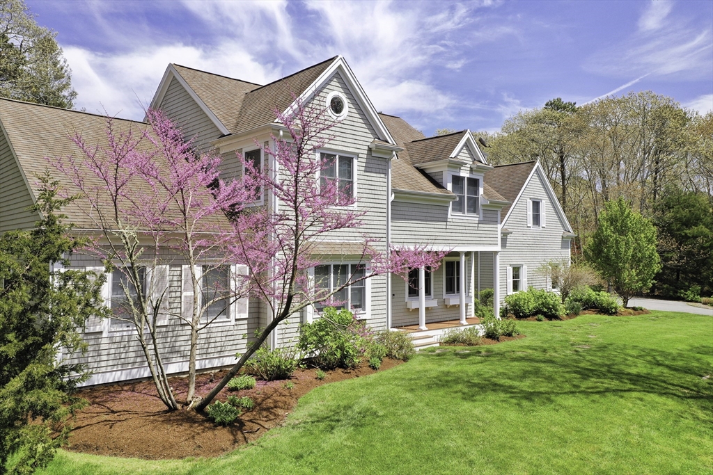 a front view of a house with a yard and potted plants