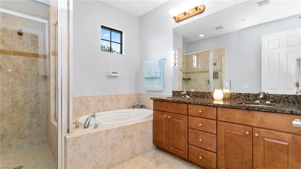 9080 Chula Vista Street, Unit 10401 Naples, FL 34113 - Photo 25 of 49 a bathroom with a granite countertop tub sink and mirror
