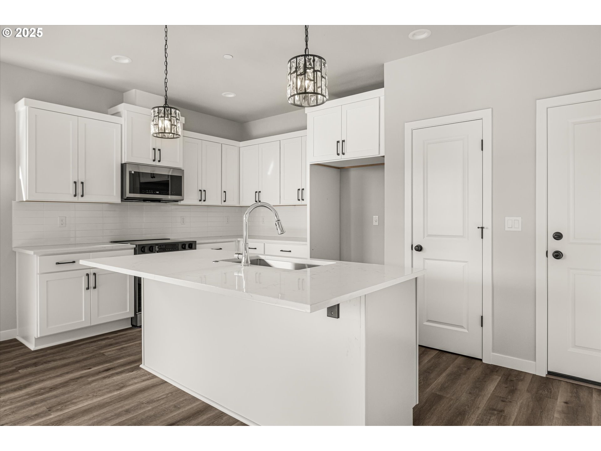 2360 Northwest 3rd Street Gresham, OR 97030 - Photo 11 of 45 a kitchen with kitchen island a sink and a stove top oven with white cabinets