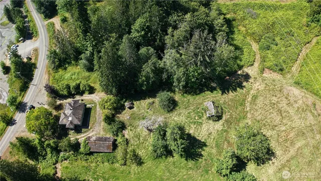 an aerial view of residential house with outdoor space and trees all around