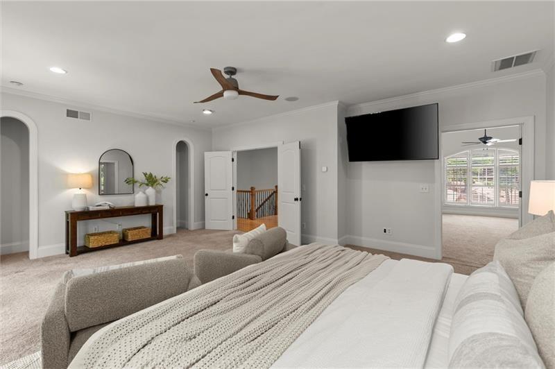 4290 Bobbins Way Cumming, GA 30041 - Photo 61 of 133 a bedroom with a bed a mirror and a flat screen tv