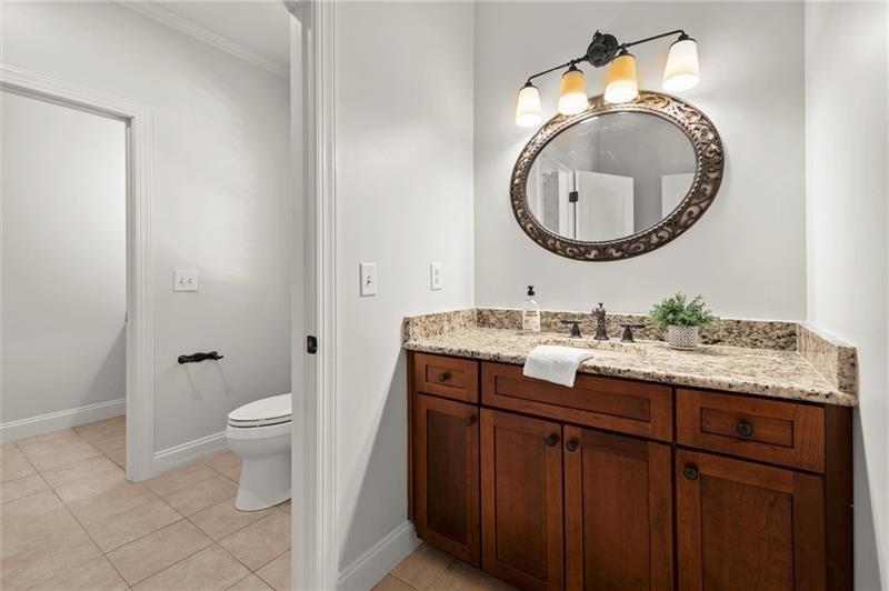 4290 Bobbins Way Cumming, GA 30041 - Photo 72 of 133 a bathroom with a granite countertop toilet a sink and a mirror