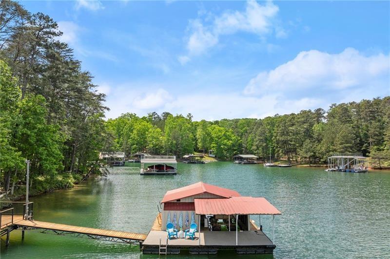 4290 Bobbins Way Cumming, GA 30041 - Photo 99 of 133 a view of a lake with a table and chairs under an umbrella