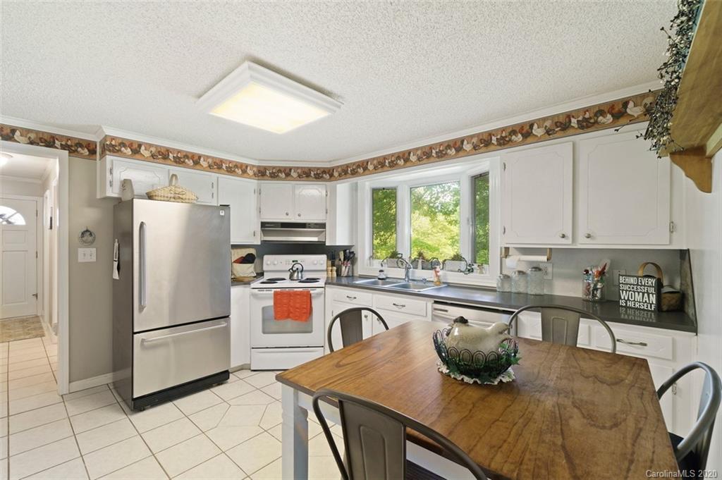 185 Hunter Bridge Road Stony Point, NC 28678 - Photo 9 of 47 a kitchen with stainless steel appliances granite countertop a refrigerator a sink a stove and white cabinets