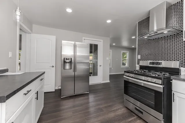 a kitchen with stainless steel appliances granite countertop a stove and a refrigerator