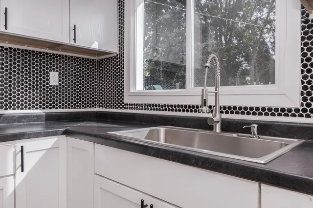 a close view of a sink and dishwasher with wooden floor