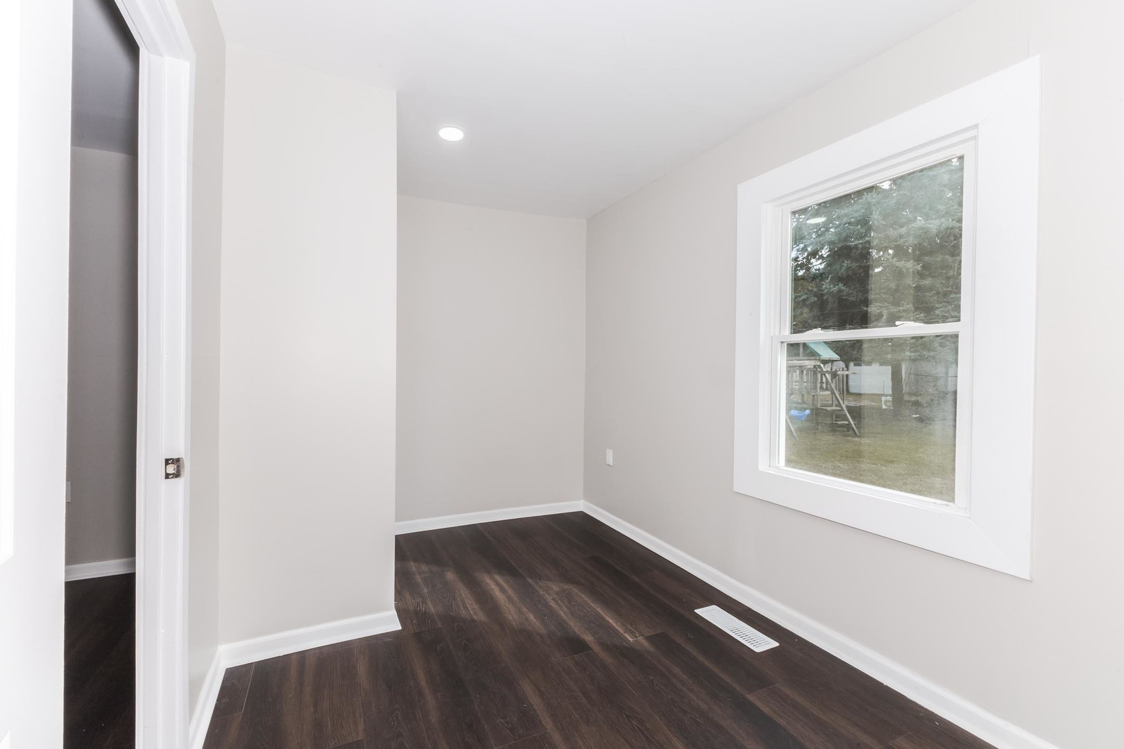 306 East Martin Street Forrest, IL 61741 - Photo 20 of 32 a view of an empty room with wooden floor and a window