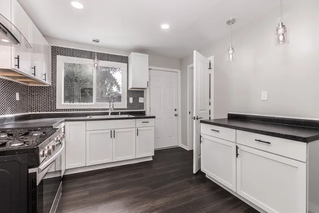 a kitchen with granite countertop white cabinets and white appliances