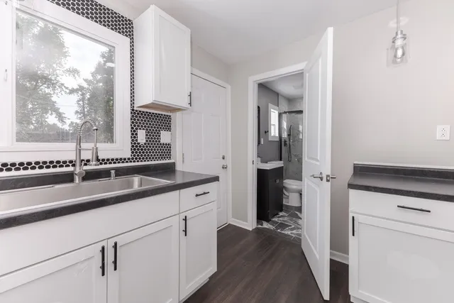 a kitchen with a sink and a wooden floor