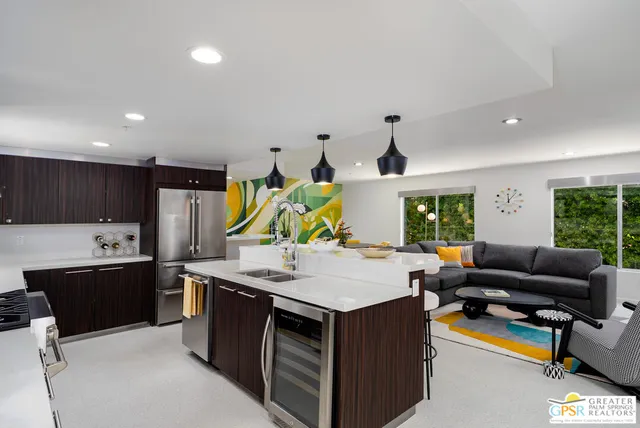 a kitchen with stainless steel appliances a sink a stove and chairs