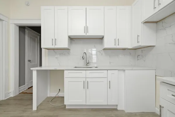 a kitchen with white cabinets and a sink