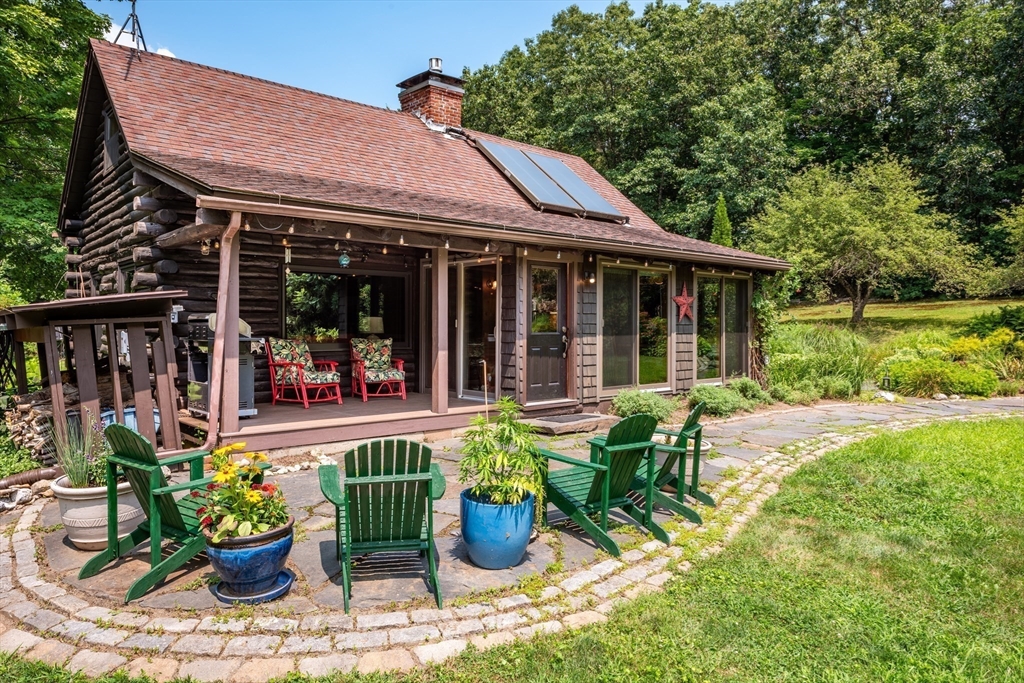 82 Juggler Meadow Road Leverett, MA 01054 - Photo 5 of 41 a view of a chair and tables in the patio in front of a house