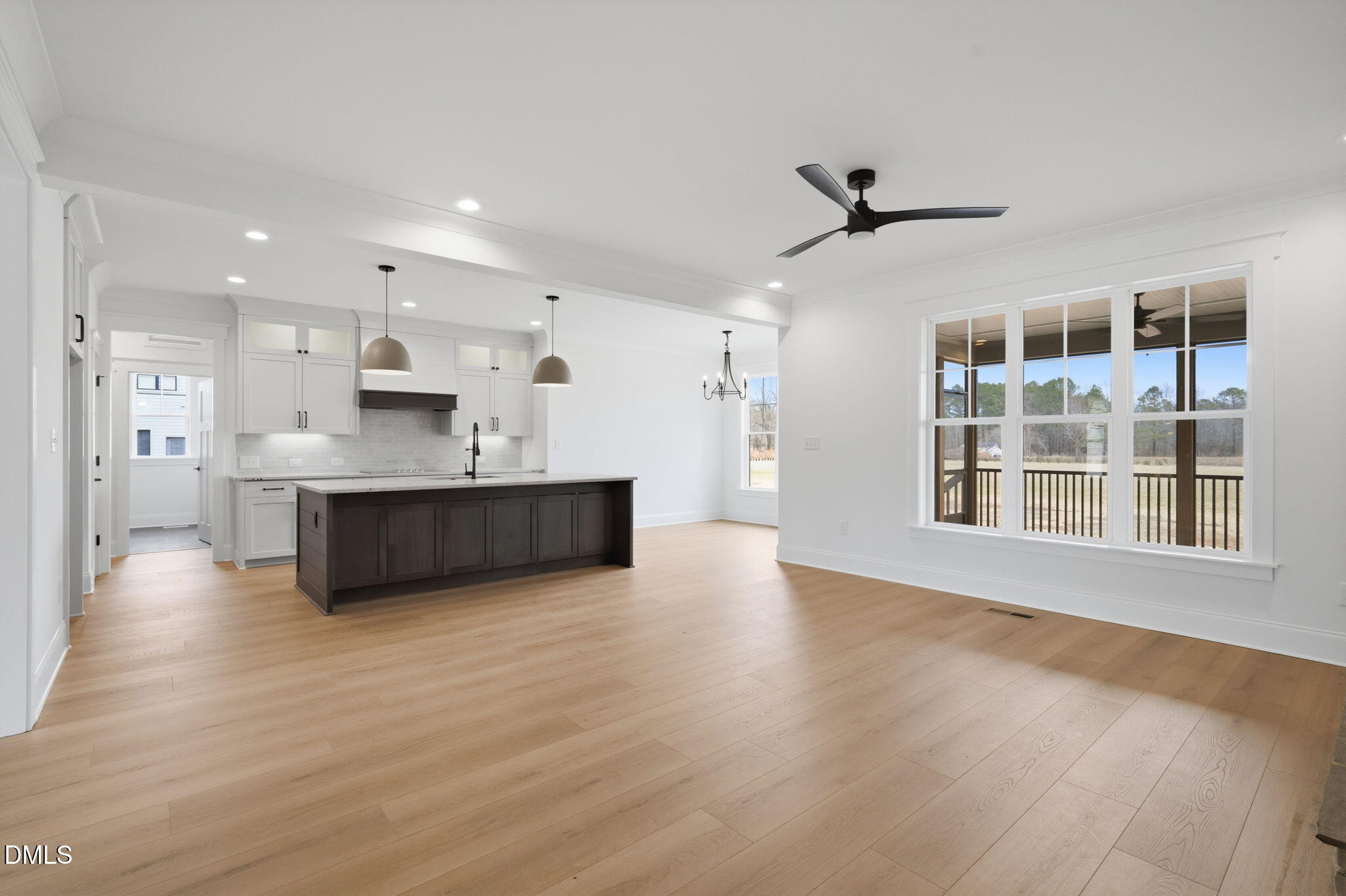 11214 Old Beulah Road Kenly, NC 27542 - Photo 14 of 56 a view of a kitchen with kitchen island a sink wooden floor and a large window